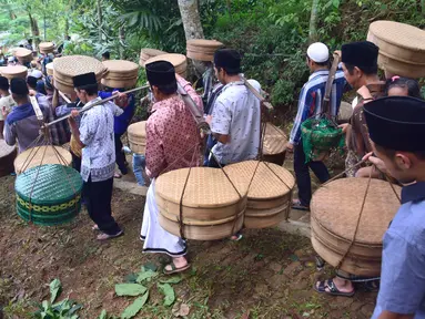 Sejumlah warga membawa tenongan yang berisi makanan saat mengikuti prosesi Sadranan Asyura di makam kiai kramat yang berada di bukit Tlogo Pucang, Kandangan, Temanggung,  Rabu  (12/10).  (Liputan6.com/Gholib)