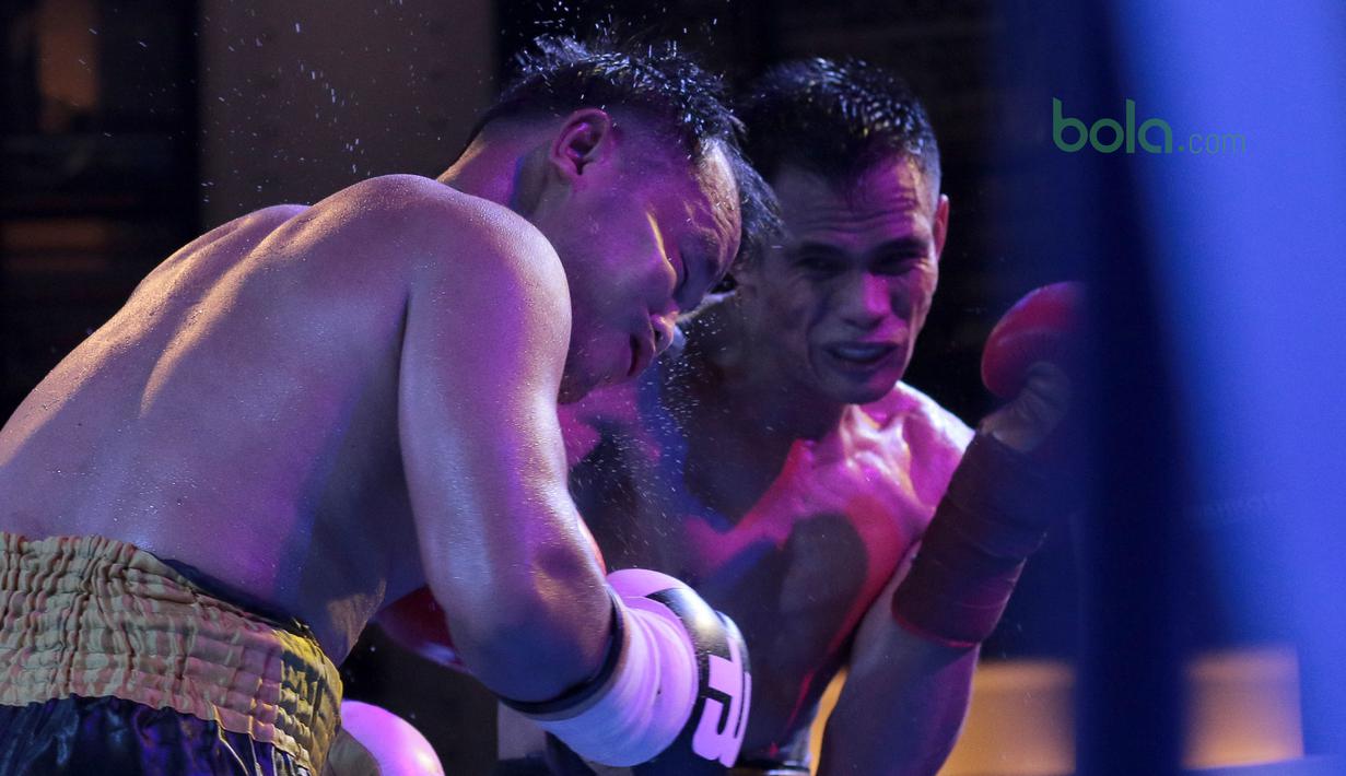 Ilham Leoisa (kanan) mendaratkan pukulan di wajah petinju Thailand, Paiboon Lorkham pada laga kelas Super-Lightweight Mahkota Boxing Super Series di Cilandak Town Square, Jakarta (10/3/2018). Ilham menang angka mutlak. (Bola.com/Nick Hanoatubun)
