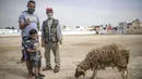 Keluarga berpose untuk foto setelah membeli seekor domba untuk perayaan Idul Adha di sebuah pasar di pinggiran Rabat, Maroko, Kamis (30/7/2020). (AP Photo/Mosaab Elshamy)