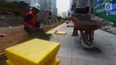 Pekerja menyelesaikan  penataan jalur pedestrian di sepanjang Jalan Jenderal Sudirman - Jalan MH Thamrin, Jakarta, Selasa (10/7). Pelebaran trotoar untuk mendukung perhelatan Asian Games itu  hingga kini belum rampung. (Merdeka.com/Imam Buhori)
