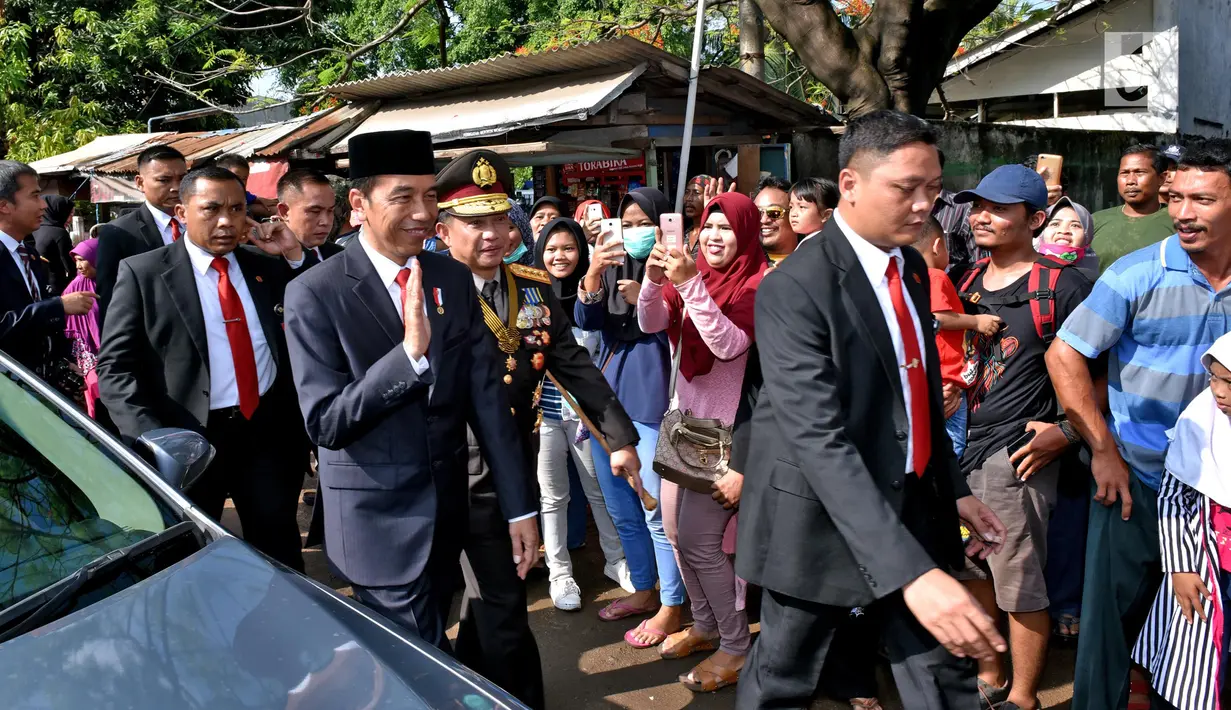 Presiden Joko Widodo didampingi Kapolri, Tito Karnavian dan rombongan berjalan kaki menuju lokasi upacara HUT ke-72 TNI di Pelabuhan Indah Kiat, Banten (5/10). Presiden Jokowi berjalan sejauh 2,5 km menuju lokasi upacara. (Liputan6.com/Pool/Agus Suparto)