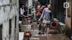 Warga membersihkan lumpur dan sampah saat banjir di permukiman Kebon Pala, Jatinegara, Jakarta, Minggu (25/10/2020). Hampir 12 jam banjir kiriman dari Bogor itu masih merendam permukiman warga di RT 11 RW 05 Kebon Pala dengan ketinggian mencapai pinggang orang dewasa.  (merdeka.com/Iqbal Nugroho)