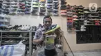 Bajuri (45) saat memasarkan sepatu impor bekas melalui media sosial di toko Second BJR, Kali Baru Timur, Cilincing, Jakarta Utara, Rabu (1/6/2022). Bursa sepatu impor bekas bermerek dalam beberapa tahun terakhir mulai ramai diminati warga lantaran harga yang terjangkau dan kualitas bahan. (merdeka.com/Iqbal S. Nugroho)