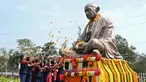 Sejumlah siswa sekolah menaburkan bunga pada patung Mahatma Gandhi pada hari peringatan kematiannya di Hyderabad, India, Senin (30/1/2023). Pada 30 Januari 1948, pemimpin spiritual dan gerakan politik kemerdekaan India Mahatma Gandhi tewas terbunuh. Mahatma Gandhi tewas ditembak oleh seorang ekstremis Hindu Nathuram Godse. (NOAH SEELAM/AFP)
