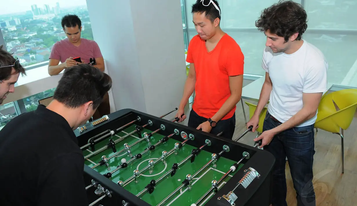 Justin Khan (Justin.tv), Daniel Kan (Exec), Tikhon Bernstam (Scribd & Parse), Ammon Bartram (SocialCam) dan Kevin Hale (Y Combinator) saat bermain foosball di Liputan6.com, Selasa (06/5/14). (Liputan6.com/Fasial R Syam)