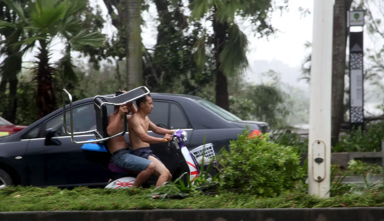 Warga mengendarai sepeda motor usai Topan Mujigae menerjang Zhanjiang, Provinsi Guangdong, China, Minggu (4/10). Topan dengan kecepatan angin hingga 180 km per jam menghantam pantai selatan China dan menewaskan sedikitnya empat orang. (REUTERS/Stringer)