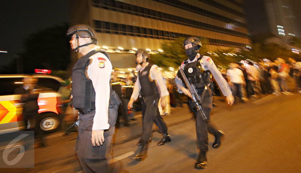 Polisi bersenjata lengkap berjaga di area gedung Jaya, Jalan MH Thamrin, Jakarta Pusat, Kamis (14/1). Kencangnya ledakan di seberang kafe kopi tersebut membuat sejumlah polisi yang ada di dekat lokasi berhamburan. (Liputan6.com/Immanuel Antonius)