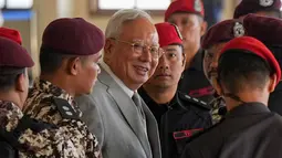 Saat ini, mantan Perdana Menteri Malaysia, Najib Razak, yang kini berusia 72 tahun, masih menjalani masa hukumannya di Penjara Kajang sejak 23 Agustus 2022 setelah dinyatakan bersalah karena menggelapkan dana sebesar RM42 juta milik SRC International Sdn Bhd. Tampak dalam foto, mantan Perdana Menteri Malaysia, Najib Razak (tengah) dikawal oleh petugas penjara saat tiba di Kompleks Pengadilan Tinggi Kuala Lumpur, Malaysia, Senin 22 Desember 2025. (AP Photo/Azneal Ishak)