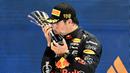 Pebalap Red Bull, Sergio Perez mencium trofi saat menjuarai Formula 1 GP Singapura 2022 di Marina Bay Street Circuit, Singapura pada 29 Mei 2021. Kemanangan ini menjadi yang keempat bagi Perez di ajang F1. (AFP/Roslan Rahman)
