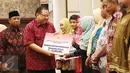 Menteri Koperasi dan UKM Puspayoga secara simbolis memberikan bantuan pemerintah melalui program Wirausaha Pemula saat sinergi program pembiayaan Kementerian Koperasi dan UMK dengan pemerintah daerah Provinsi NTB, Jumat (12/5). (Liputan6.com/Angga Yuniar)