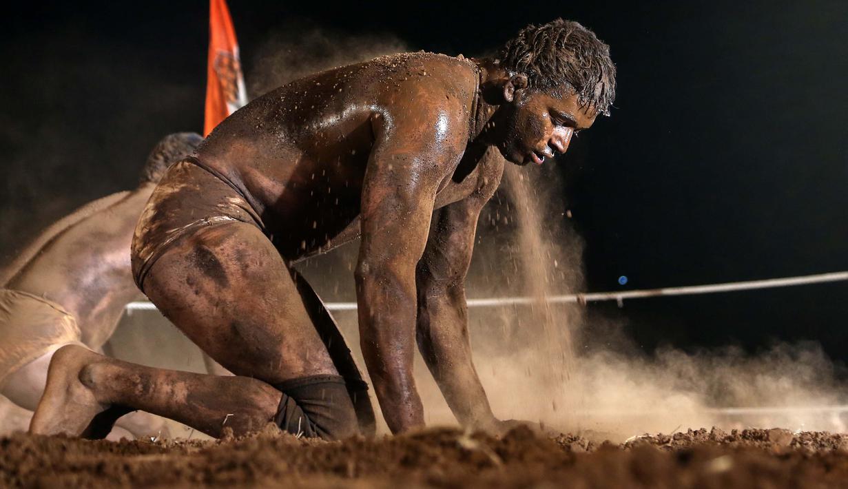 Pegulat penuh lumpur pada ajang "Indian traditional wrestling competition" atau Kushti di Arena Akhara, Mumbai, India, 20 Maret 2016. Olahraga tradisional ini terus di lestarikan sebagai bagian dari budaya. (EPA/Divyakant Solanki)