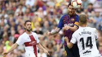 Gelandang Barcelona, Lionel Messi, duel udara dengan bek Huesca, Jorge Pulido, pada laga La Liga Spanyol di Stadion Camp Nou, Barcelona, Minggu (2/8/2018). Barcelona menang 8-2 atas Huesca. (AFP/Lluis Gene)