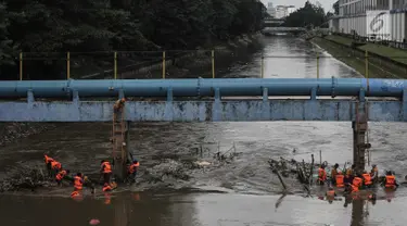 Pasukan oranye membersihkan sampah yang tersangkut di aliran sungai Ciliwung di kawasan Sudirman, Jakarta, Jumat (9/2). Meningkatnya debit air di Bendungan Katulampa, aliran air yang masuk ke Sungai Ciliwung membawa sampah. (Liputan6.com/Faizal Fanani)