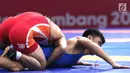 Pegulat putra Indonesia, Muhammad Aliansyah saat bertarung melawan pegulat Korea Utara Kim Myong Chol pada kelas putra 67 Kg di arena gulat JCC Senayan, Selasa (21/8). (Liputan6.com/Fery Pradolo)