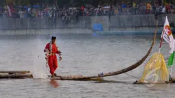 Seorang peserta melakukan atraksi melintasi dalam rangka Festival Cisadane 2015 di Tangerang, Banten, Sabtu (23/5/2015). Sebanyak 100 perahu nusantara menampilkan berbagai pernak-pernik budaya khas nusantara (Liputan6.com/Andrian M Tunay)