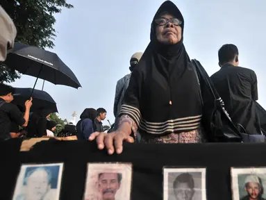 Seorang ibu yang tergabung dalam Jaringan Solidaritas Korban untuk Keadilan (JSKK) menggelar Aksi Kamisan di depan Istana Negara, Jakarta, Kamis (2/8). Aksi ini merupakan yang ke-547. (Merdeka.com/Iqbal Nugroho)