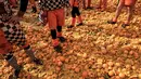 Peserta berdiri di atas tumpukan jeruk yang hancur saat tradisi "perang jeruk" selama Karnaval Ivrea di Turin, Italia, Minggu (3/3). Perang Jeruk ini dikenal juga dengan nama Battaglia Delle Arance atau Carnevale d'Ivrea. (MARCO BERTORELLO/AFP)