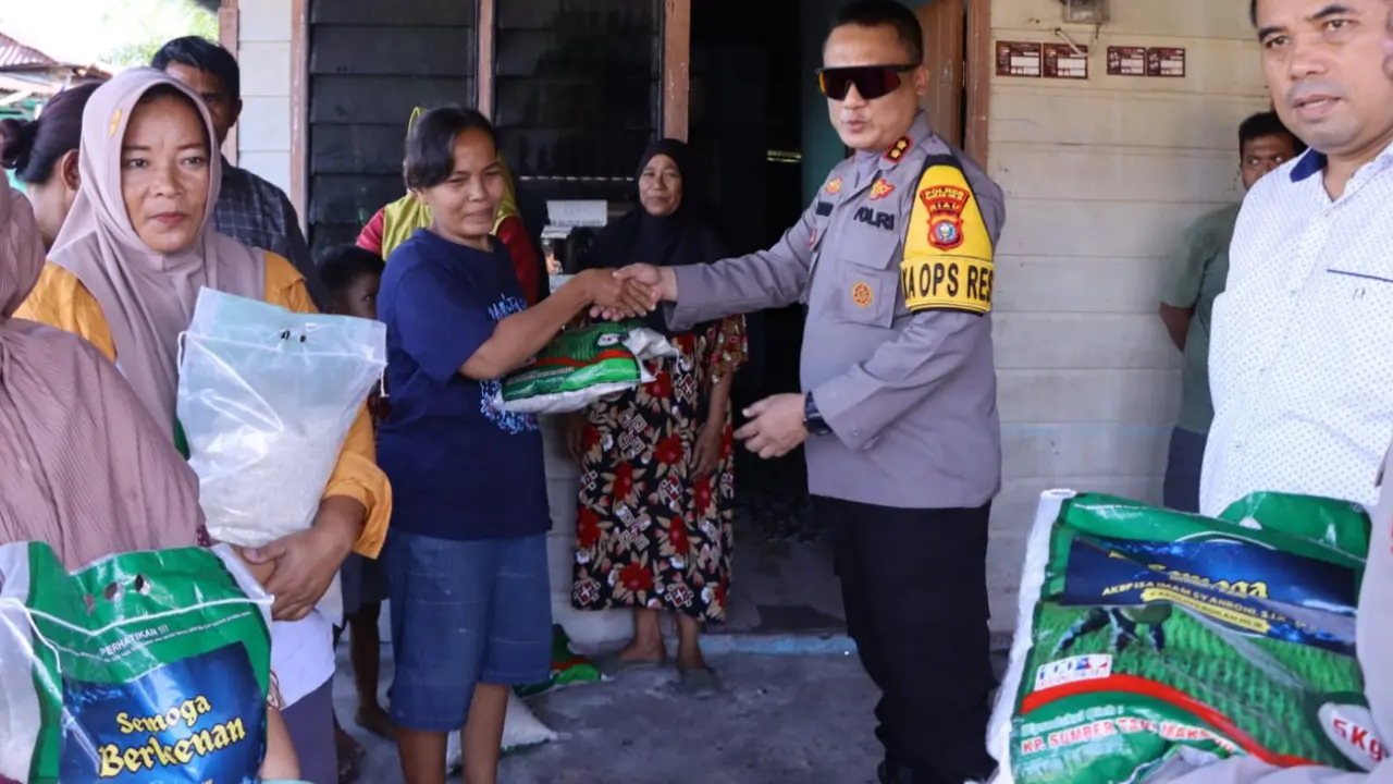 Kapolres Rokan Hilir memberikan bantuan beras kepada korban banjir.