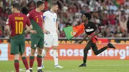 Ketika laga bergulir ada peristiwa menarik yang terjadi, yaitu seorang suporter menginvasi lapangan dengan membawa bendera Portugal. (AP Photo/Armando Franca)