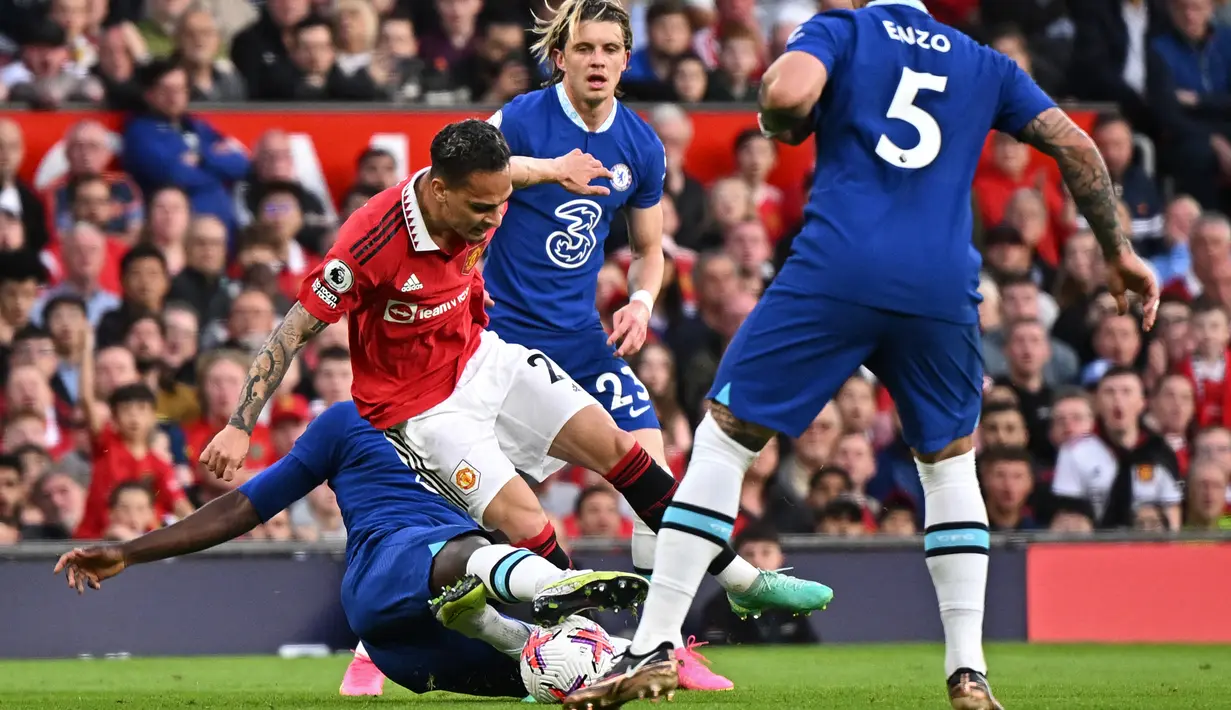 Pemain Chelsea, Trevoh Chalobah (kiri), berusaha menghentikan laju pemain Manchester United, Antony, dalam pertandingan partai tunda pekan ke-32 Liga Inggris 2022/2023 yang berlangsung di Old Trafford, Jumat (26/5/2023) dini hari WIB. (AFP/Oli Scarff)