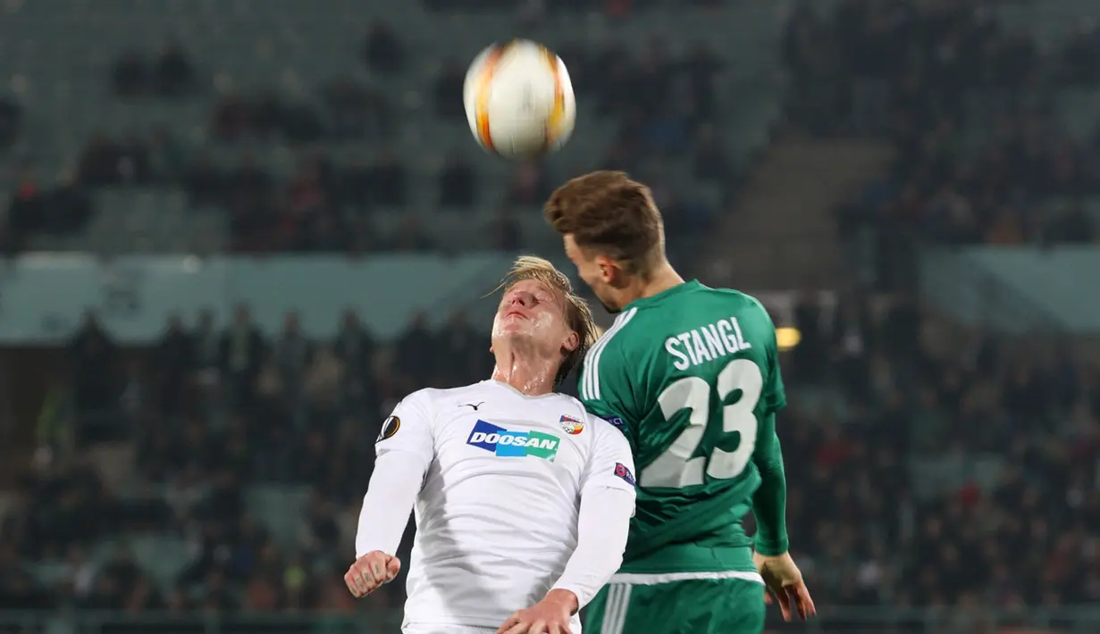 Pemain Rapid Vienna, Stefan Stangl, duel di udara dengan gelandang serang Viktoria Plzen dalam laga lanjutan Grup E Liga Europa di Stadion Ernst Happel, Wina, Austria, Jumat (23/10/2015) dini hari WIB. (Bola.com/Reza Khomaini)