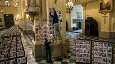 Pekerja menempelkan potret korban meninggal akibat virus corona di dalam Katedral, di Lima, Peru pada 13 Juni 2020. Misa Minggu di Katedral Lima dihadiri lebih dari 4.000 potret mereka yang telah meninggal dalam pandemi Covid-19 yang menyebar di Peru. (AP Photo/Rodrigo Abd)