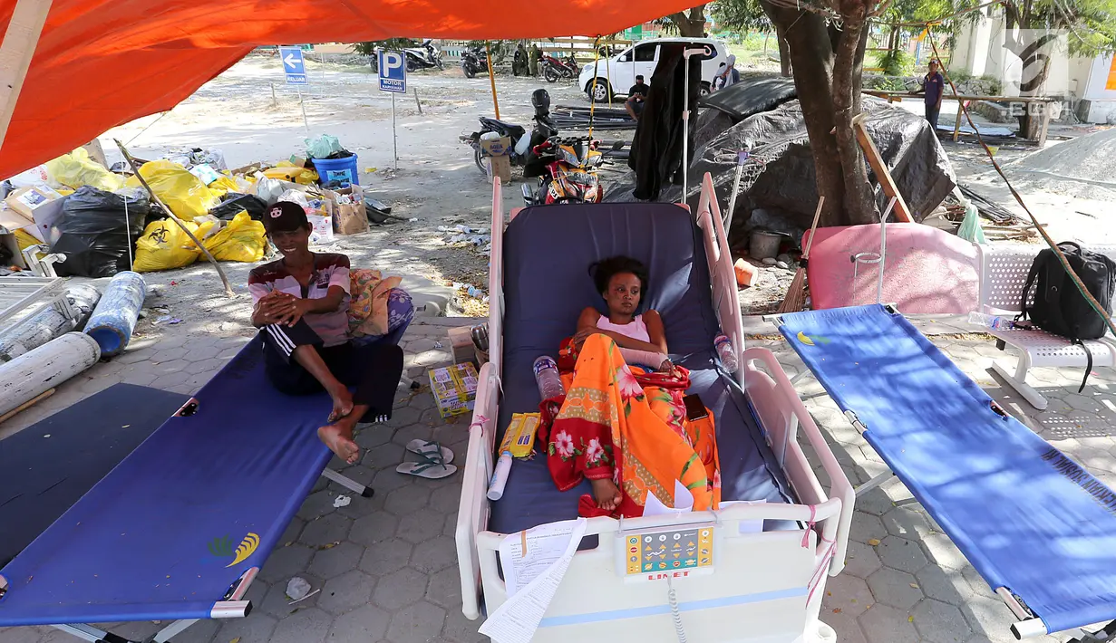 Seorang pasien korban gempa bumi dan tsunami Palu dirawat di halaman Rumah Sakit Undata, Palu, Sulawesi Tengah, Kamis (4/10). Bagian gedung di dalam rumah sakit yang rusak membuat pasien di rawat di tenda. (Liputan6.com/Fery Pradolo)