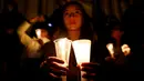 Seorang wanita membawa lilin sebagai simbol dukungan damai dalam aksi diam di Bolivar Square, Bogota, Rabu (5/10). Sebelumnya pada Minggu, 2 Oktober 2016 waktu setempat, Kolombia menggelar referendum tentang perdamaian dengan FARC. (REUTERS/John Vizcaino)