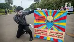 Seorang yang tergabung dalam Koalisi Masyarakat Peduli Kesehatan (KOMPAK) menunjukkan poster saat menggelar aksi #ParadeMural di kawasan Patung Arjuna Wijaya, Jakarta, Rabu (17/11/2021). Aksi tersebut untuk mendesak Presiden untuk mengesahkan Revisi PP 109/2012. (Liputan6.com/Faizal Fanani)