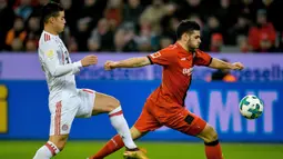 Aksi pemain Leverkusen, Kevin Volland melepaskan umpan saat dibayangi pemain Bayern Munchen, James Rodriguez (kiri) pada lanjutan Budesliga di Bay Arena, Laverkusen, (12/1/2018). Bayern Munchen menang 3-1. (AFP/Sascha Schuermann)