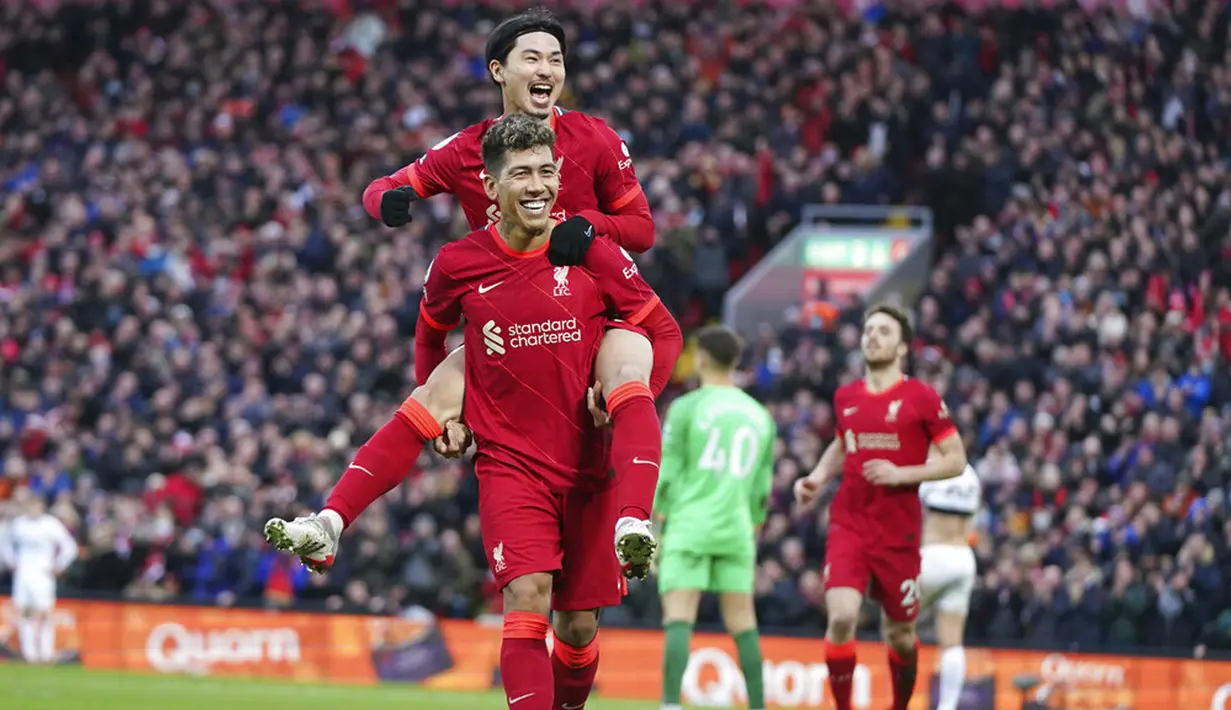 Pemain Liverpool Takumi Minamino (atas) merayakan dengan Roberto Firmino usai mencetak gol ke gawang Brentford pada pertandingan sepak bola Liga Inggris di Anfield, Liverpool, Inggris, 16 Januari 2022. Liverpool menang 3-0. (AP Photo/Jon Super)