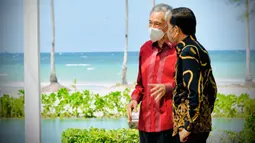 Setelah menyampaikan pernyataan pers bersama dan sebelum melakukan jamuan santap siang, Presiden Joko Widodo (kanan) dan PM Singapura Lee Hsien Loong berbincang dengan latar belakang pantai di The Shancaya Resort Bintan, Bintan, Kepulauan Riau, Selasa (25/1/2022). (Laily Rachev/Biro Pers Setpres)