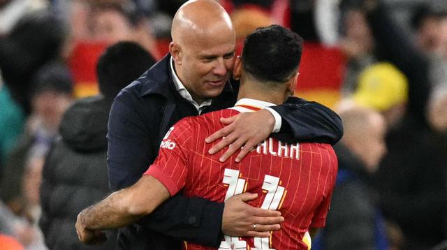 Pelatih Liverpool asal Belanda, Arne Slot (kiri), memeluk striker Liverpool asal Mesir bernomor punggung 11, Mohamed Salah, setelah pertandingan sepak bola Liga Champions UEFA antara Liverpool dan Real Madrid di Anfield, Liverpool, barat laut Inggris, pada 27 November 2024. Liverpool memenangkan pertandingan dengan skor 2-0. (Oli SCARFF/AFP)