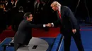 Capres AS dari Partai Republik, Donald Trump berjabat tangan dengan presenter Fox News Chris Wallace yang menjadi moderator seusai perhelatan debat ketiga dan terakhir capres AS di University of Nevada, Las Vegas, Rabu (19/10). (REUTERS/Mark Ralston/Pool)