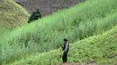 Petugas polisi bersenjata lengkap berjaga di di sebuah ladang di Indrapuri, Aceh, Kamis (26/4). Ladang tersebut berada sekitar 4 kilometer dari permukiman warga. (AFP/Chaideer Mahyuddin)