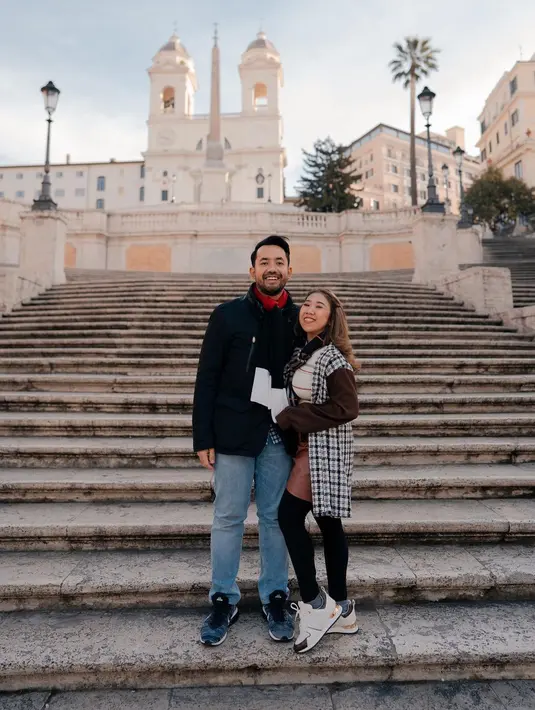 Keduanya tampil dengan outfit bermotif. Kiky memilih mengenakan atasan bergaris berwarna cokelat muda, dengan rok pendek kulit berwarna cokelat yang lebih gelap, dan legging hitam. Ini masih ditumpuknya dengan oversized kemeja bergaris dengan lengan berbeda. Sedangkan suaminya memilih kemeja sebagai dalaman, yang ditumpuk dengan blazer hitam, dipadu dengan celana panjang jeans. Keduanya juga tampak mengenakan syal di leher masing-masing. Foto: Instagram.