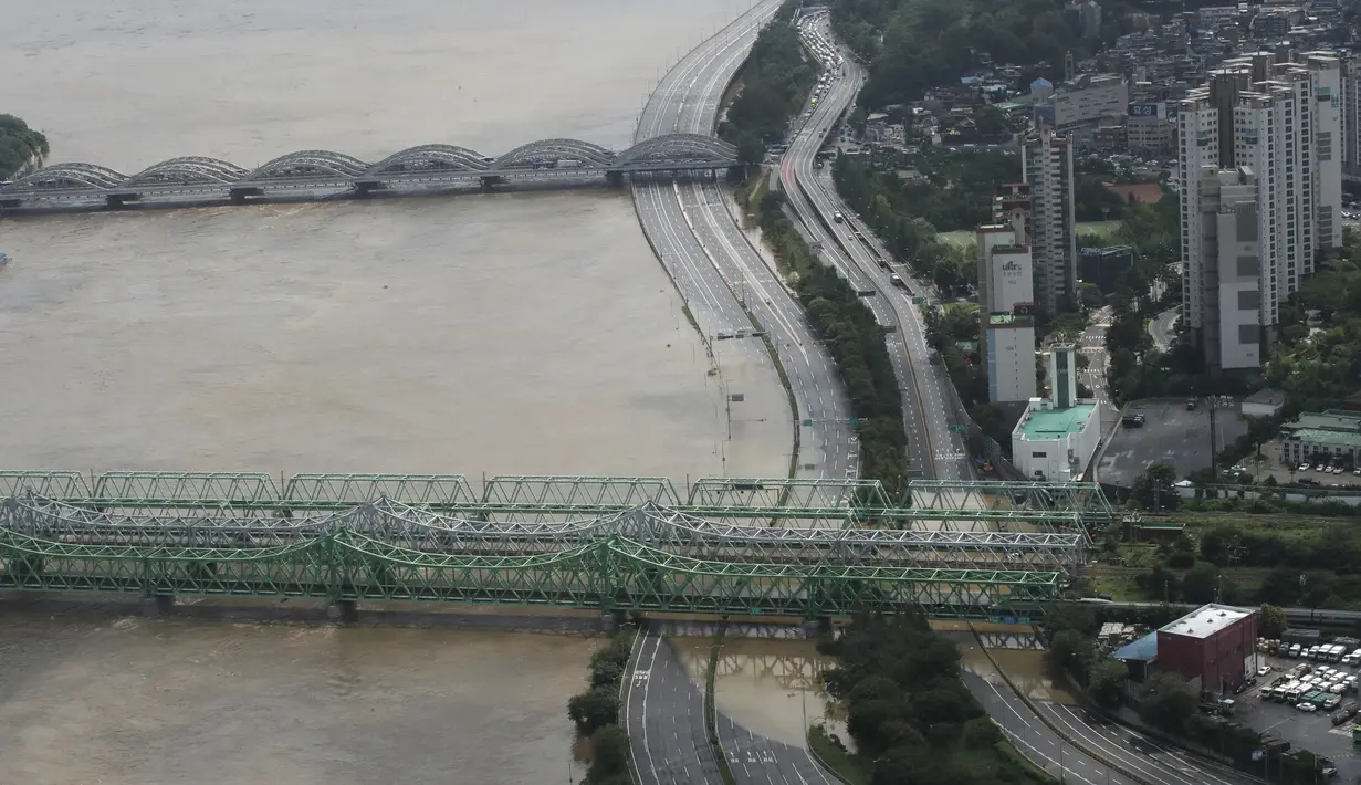 Sebagian jalan utama dekat Sungai Han terendam banjir akibat hujan lebat di Seoul, Korea Selatan, Kamis (6/8/2020). Hujan lebat terus mengguyur Korea Selatan, mendorong pihak berwenang untuk menutup sebagian jalan raya dan mengeluarkan peringatan banjir. (AP Photo/Lee Jin-man)
