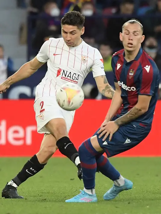 <p>Pemain Sevilla Gonzalo Montiel (kiri) berebut bola dengan pemain Levante Son pada pertandingan Liga Spanyol di Stadion Ciutat de Valencia, Valencia, Spanyol, 21 April 2022. Sevilla menang 3-2. (Jose Jordan/AFP)</p>