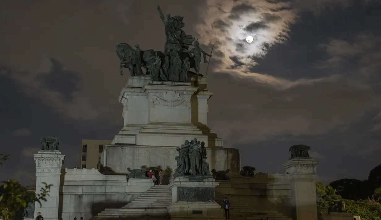 Bulan purnama muncul di belakang monumen Kemerdekaan di Sao Paulo, Brasil, Minggu (15/5/2022). (AP Photo/Andre Penner)