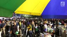 Warga menikmati car free night saat malam pergantian tahun di Jalan MH Thamrin, Jakarta, Senin (31/12). Hujan yang mengguyur Jakarta sejak siang tidak menyurutkan antusias warga menikmati car free night. (Liputan6.com/Angga Yuniar)