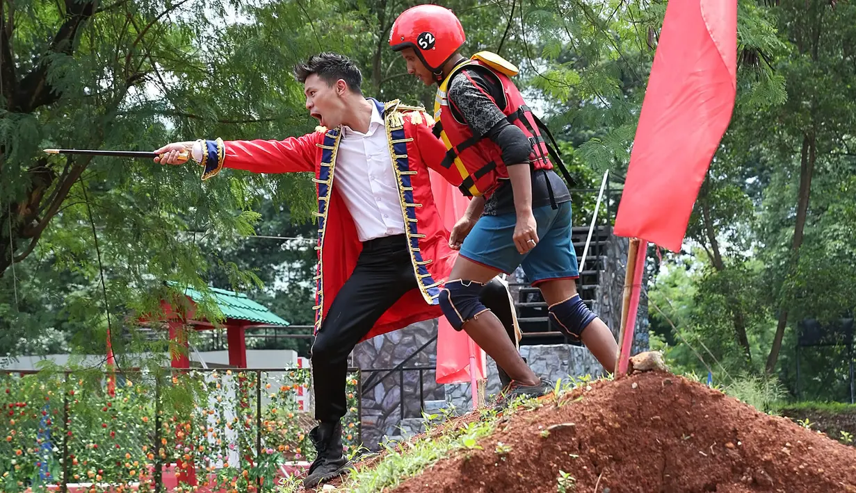 Bersama para peserta, kapten tampak begitu bersemangat ketika memberikan dukungan peserta yang sedang berjuang dalam rintangan tersebut. Mengenakan jubah ala Raja dan tongkat yang tak ketinggalan. (Bambang E. Ros/Bintang.com)