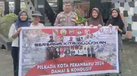 Personel Polresta Pekanbaru menyambangi masyarakat mengampanyekan Pilkada damai. (Liputan6.com/M Syukur)