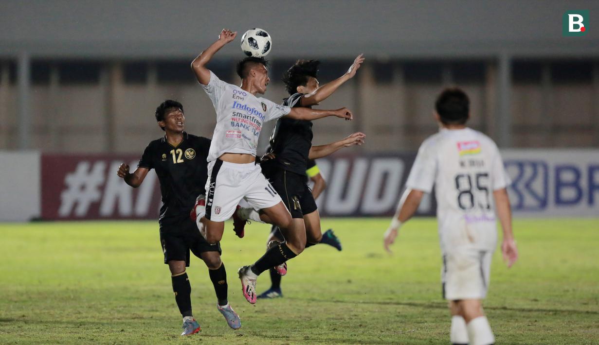 Gelandang Timnas Indonesia, Feby Eka Putra, duel udara dengan penyerang Bali United, Lerby Eliandry, pada laga uji coba di Stadion Madya, Jakarta, Minggu (7/3/2021). Indonesia menang dengan skor 3-1. (Bola.com/ Ikhwan Yanuar Harun)