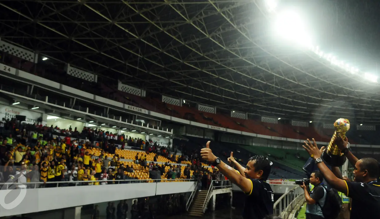 Pelatih Mitra Kukar, Jafri Sastra menyapa suporternya saat merayakan kemenangan atas Semen Padang pada final turnamen Piala Jenderal Sudirman, Minggu (24/1/2016). Mitra Kukar unggul 2-1 atas Semen Padang. (Liputan6.com/Helmi Fithriansyah)