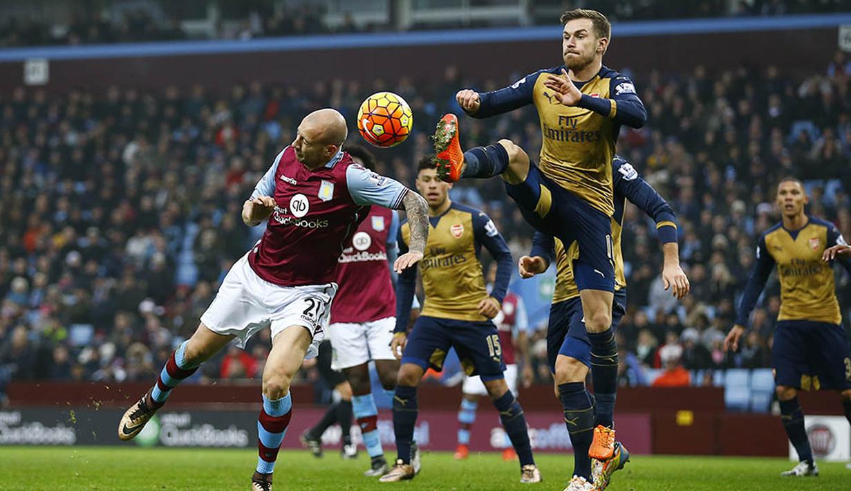 Gelandang Arsenal, Aaron Ramsey, berebut bola dengan pemain Aston Villa, Alan Hutton, pada laga Liga Premier Inggris di Stadion Villa Park, Inggris, Minggu (13/12/2015). (Reuters/Darren Staples)