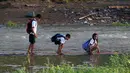 Sejumlah bocah saat menyeberangi sungai untuk menuju sekolah di sebuah desa terpencil di Montalban, Rizal, Filipina, Senin (13/6). Tidak adanya fasilitas jembatan membuat para siswa mempertaruhkan keselamatannya. (REUTERS/Erik De Castro)
