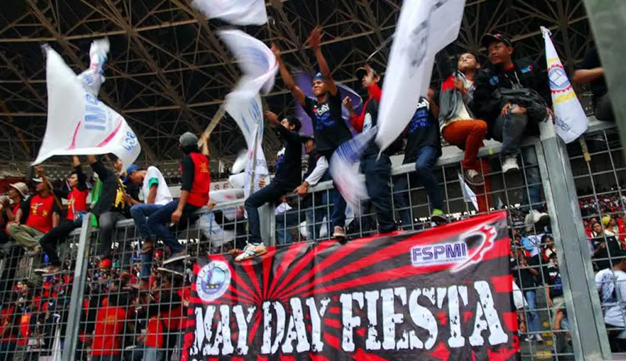 Beberapa pengunjuk rasa tampak menaiki pagar sambil mengibarkan bendera yang merupakan simbol kebesaran organisasi buruh (Liputan6.com/Miftahul Hayat)
