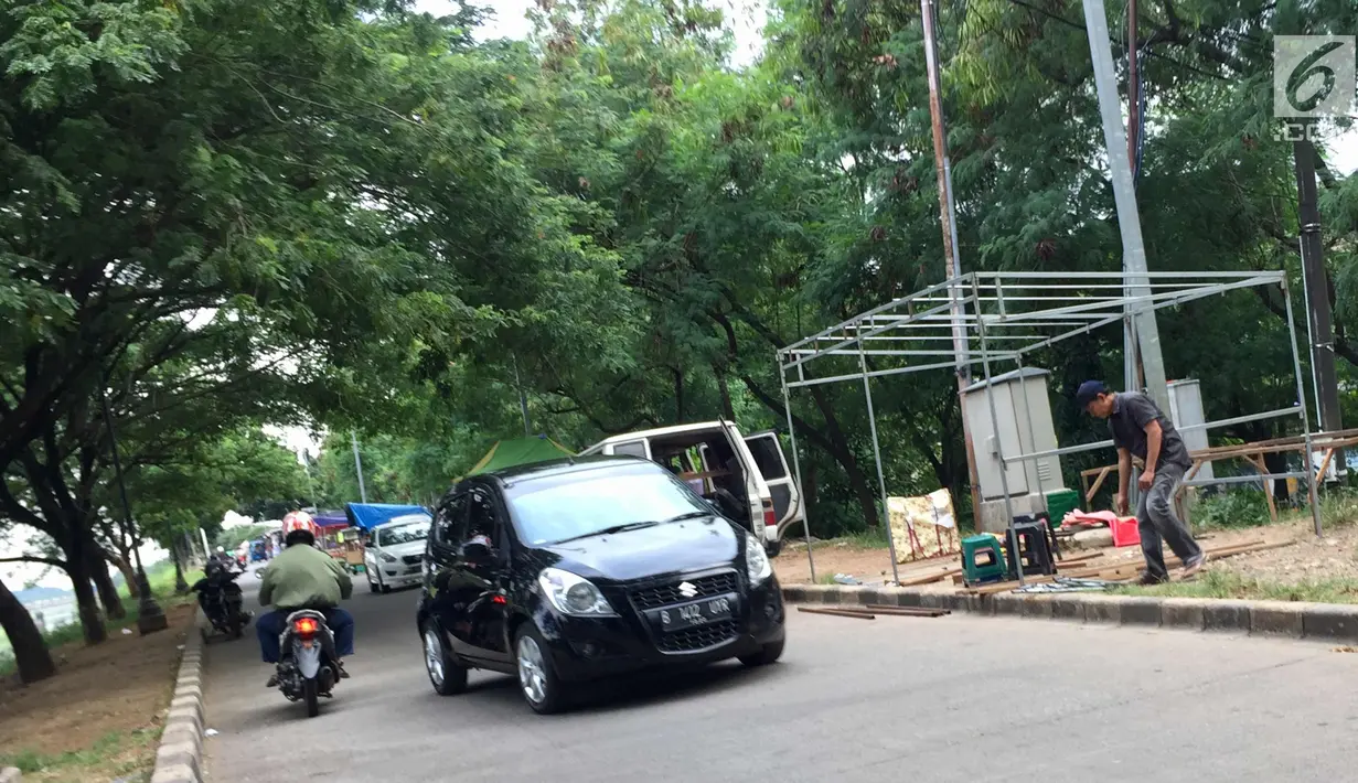 PKL memasang tenda untuk berdagang di Jalur Inspeksi Kanal Banjir Timur, Jakarta, Rabu (3/1). Kurangnya pengawasan menyebabkan jalur inspeksi tersebut dipenuhi PKL sehingga mengganggu ketertiban umum. (Liputan6.com/Immanuel Antonius)