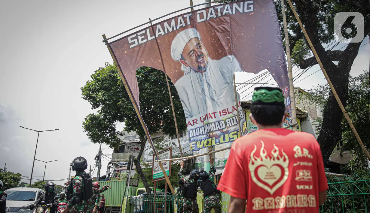 Seorang warga meminta anggota TNI untuk tidak mencopot paksa baliho Rizieq Shihab yang terpasang di sekitar kawasan Petamburan, Jakarta, Jumat (20/11/2020). Pencopotan dilakukan karena menyalahi aturan yang telah ditetapkan. (Liputan6.com/Faizal Fanani)