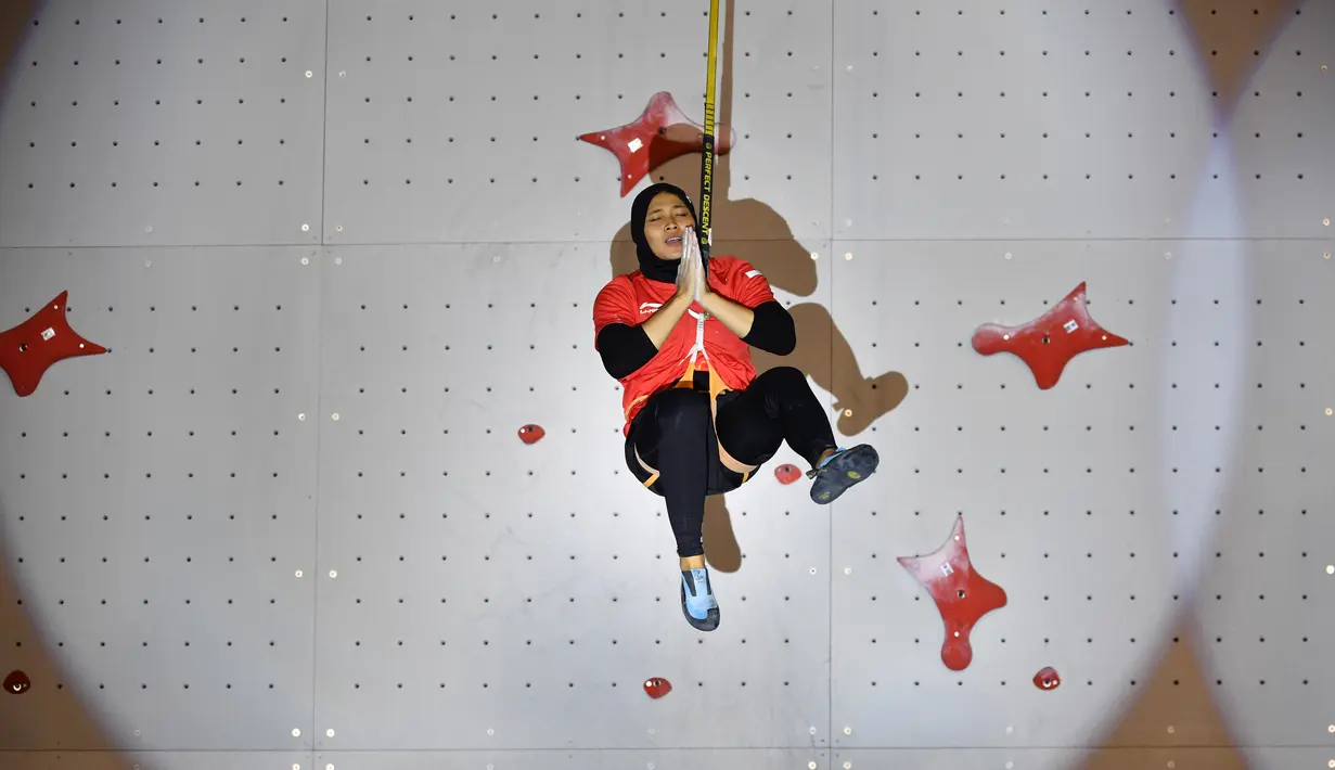 Ekspresi atlet panjat tebing Indonesia, Aries Susanti Rahayu saat memenangkan final speed climbing putri di Asian Games 2018, Palembang, Sumatera Selatan, Kamis (23/8). (AFP PHOTO/ADEK BERRY)